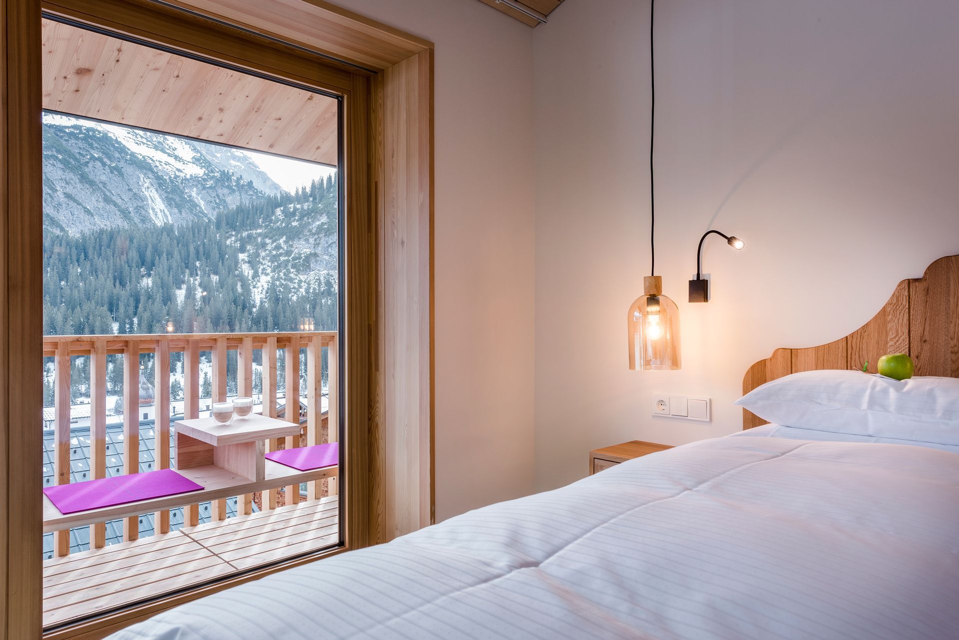 Hotelzimmer mit einem Bett und einem Balkon mit Blick auf die Berge .