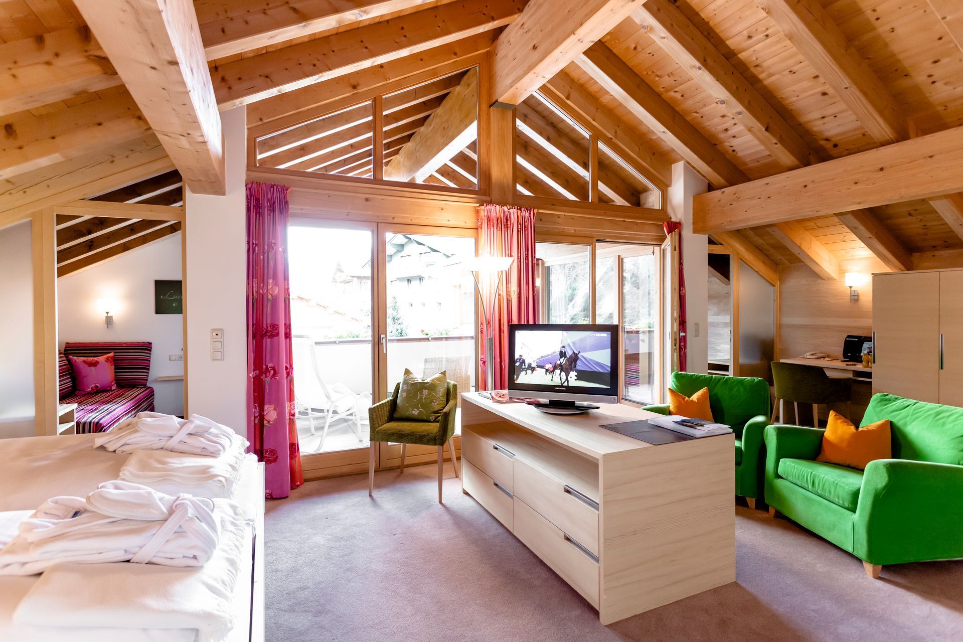 Stäfeli Hotelzimmer mit einer grünen Couch und einem Fernseher