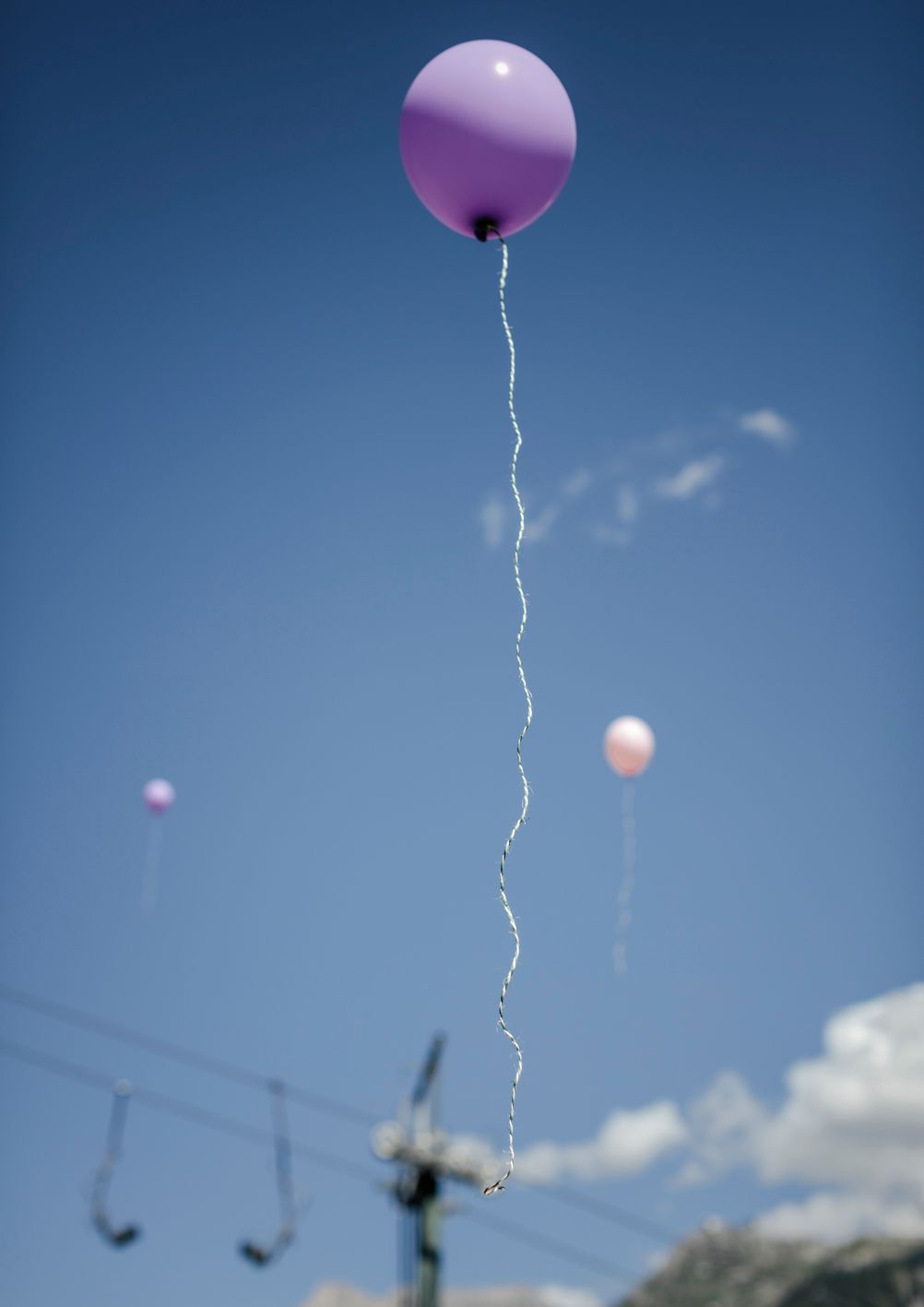 ein lila Ballon fliegt in einem blauen Himmel