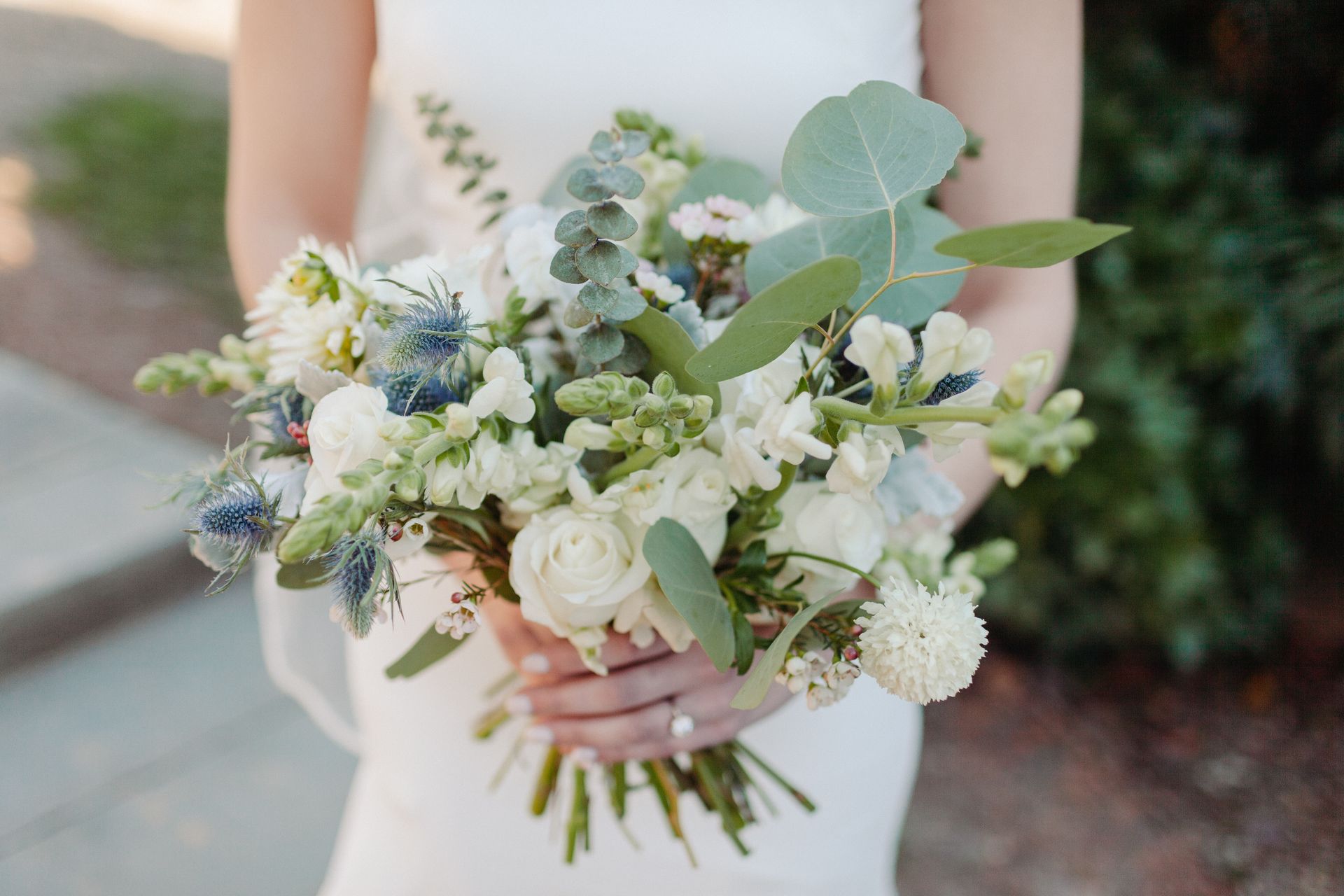 Eine Braut hält einen Blumenstrauß in ihren Händen .