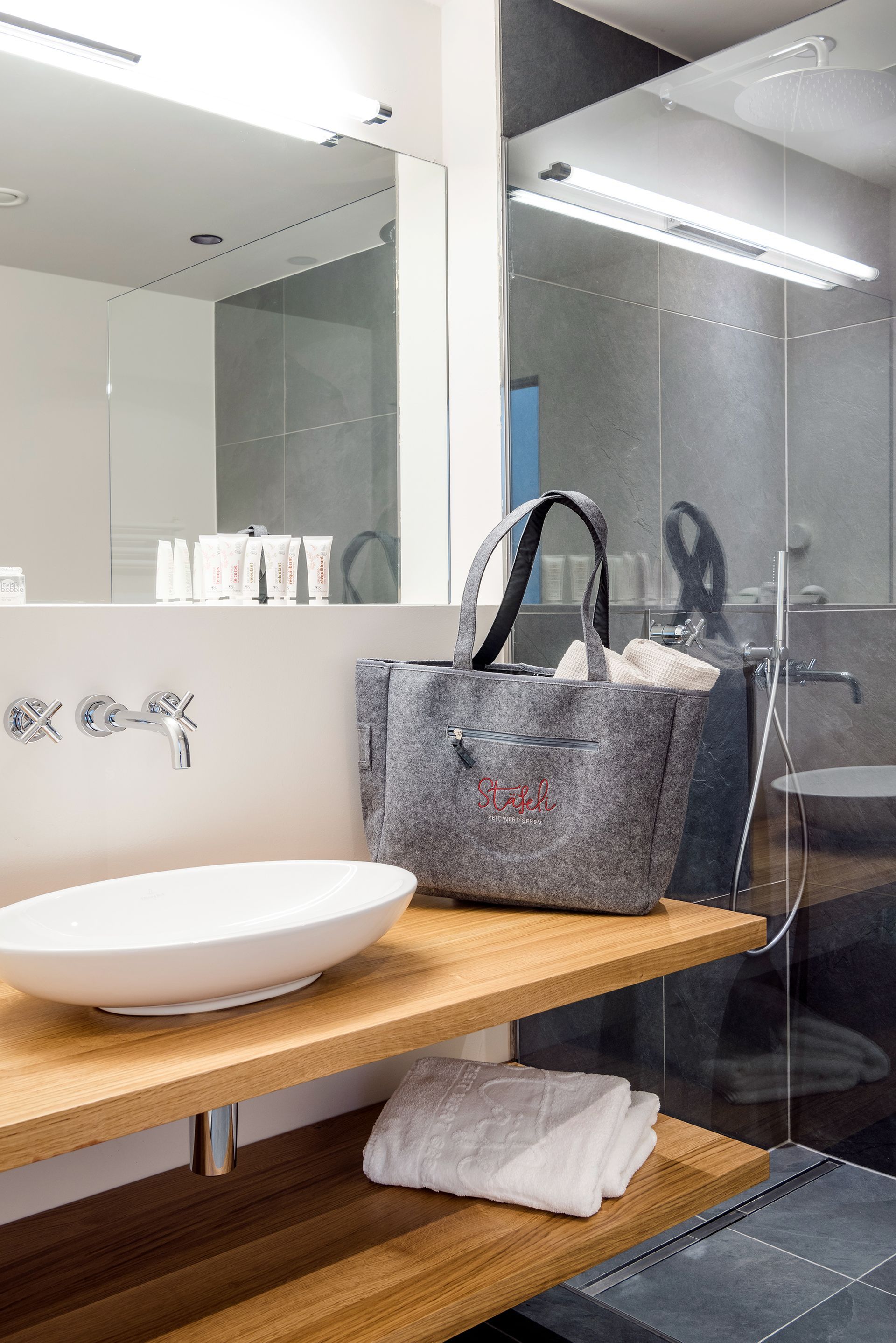 ein Badezimmer mit einem Waschbecken , einem Spiegel und einer Handtasche .
