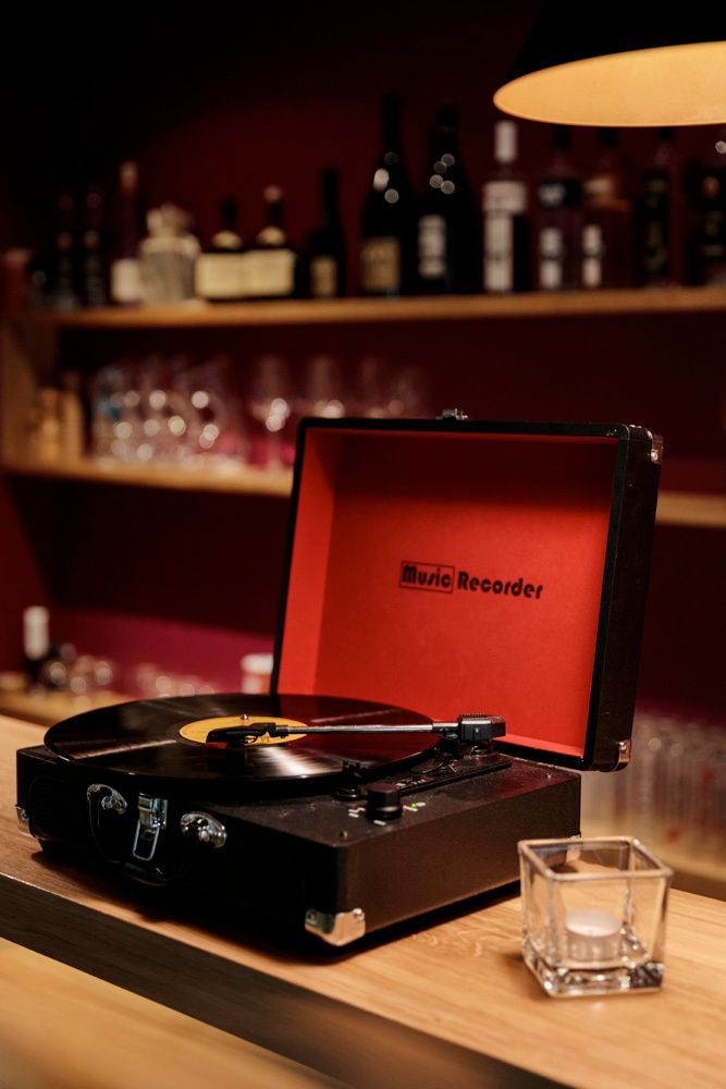 ein Plattenspieler steht auf einem Holztisch neben einer Kerze .