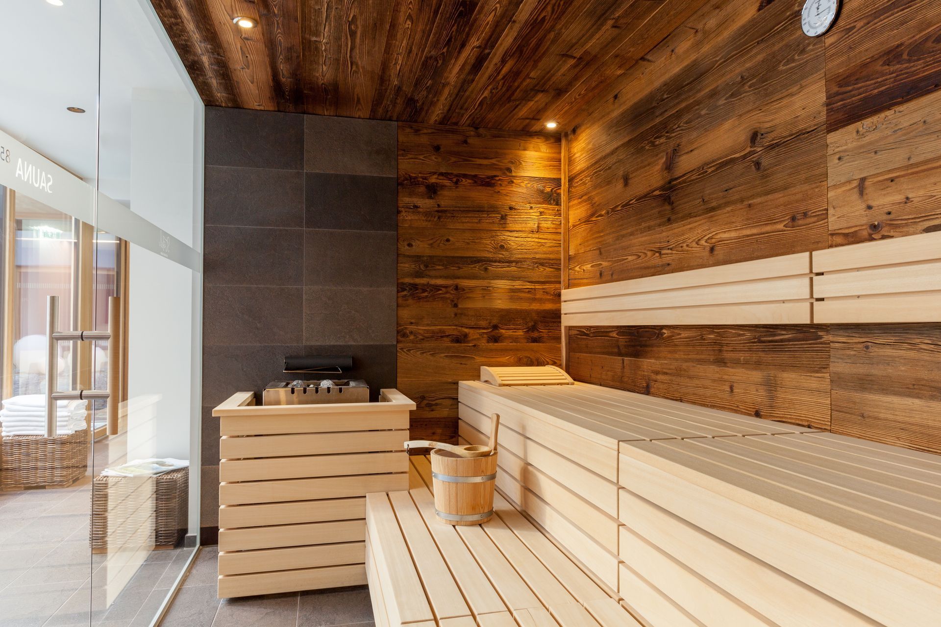 eine Sauna mit Holzwänden und einer Glastür .