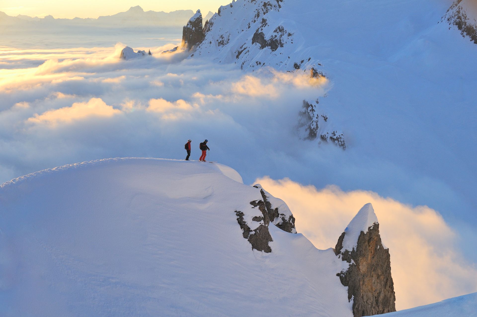 Zwei Menschen stehen am Rand eines schneebedeckten Berges .