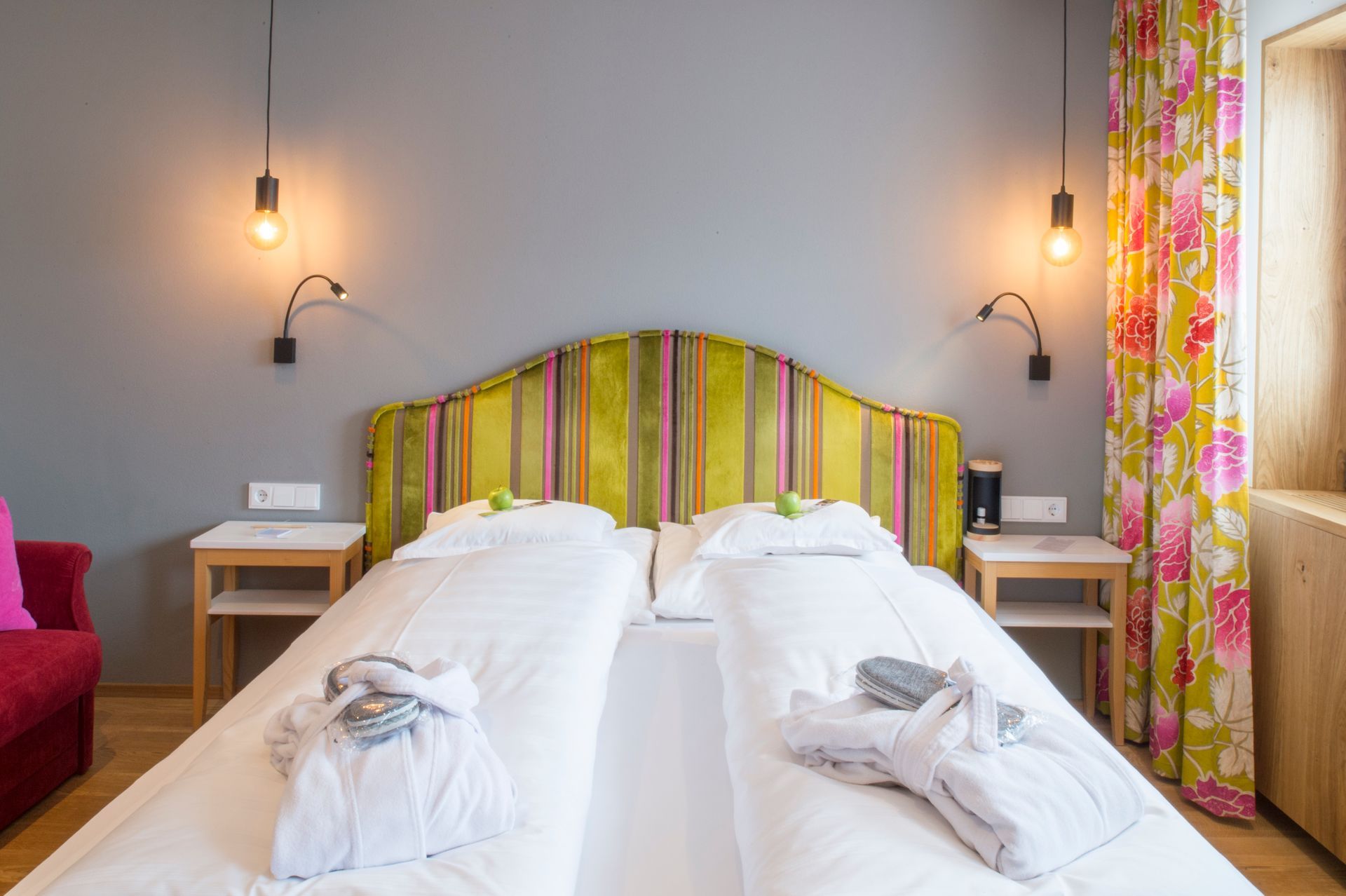 ein Hotelzimmer mit gestreiftem Bett und Nachttischen