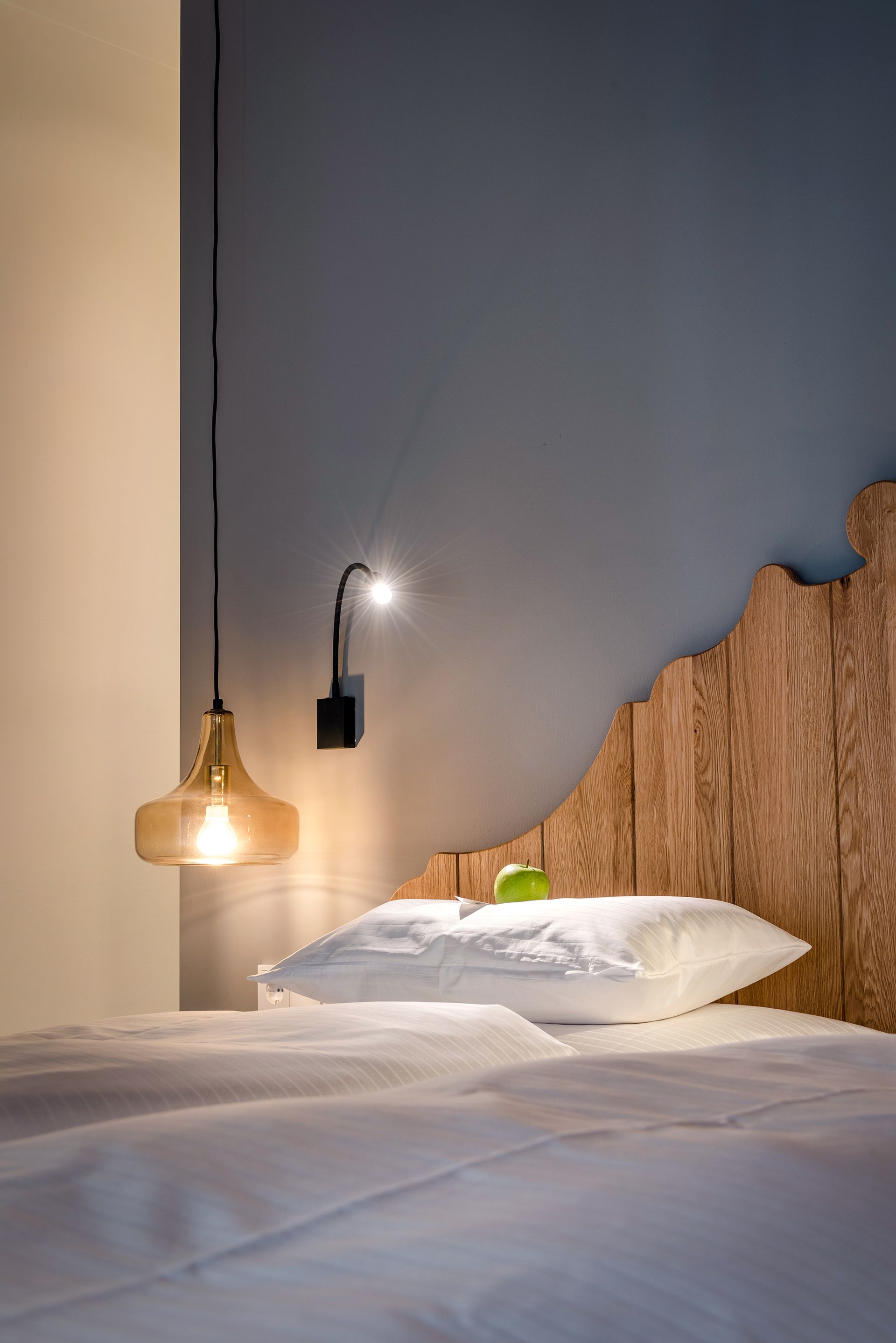 Hotelzimmer mit einem Bett , einer Lampe und einem Holzkopfteil .