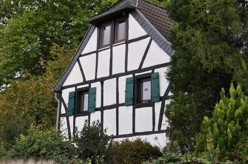 Ein weiß-schwarzes Haus mit grünen Fensterläden