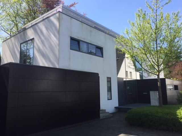 Ein weißes Haus mit einem schwarzen Garagentor