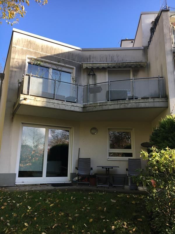 Die Rückseite eines Hauses mit Balkon und Stühlen