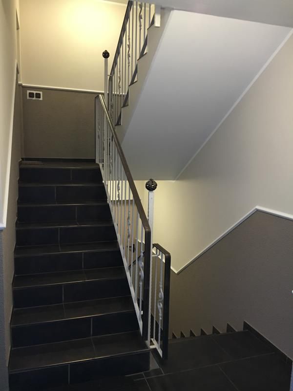 Eine schwarze Treppe mit weißem Geländer