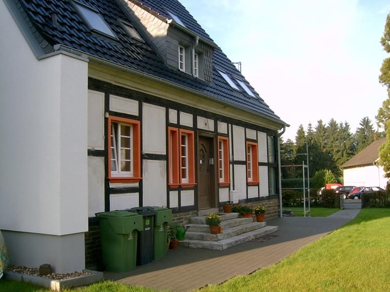 Ein Haus mit einer grünen Mülltonne davor