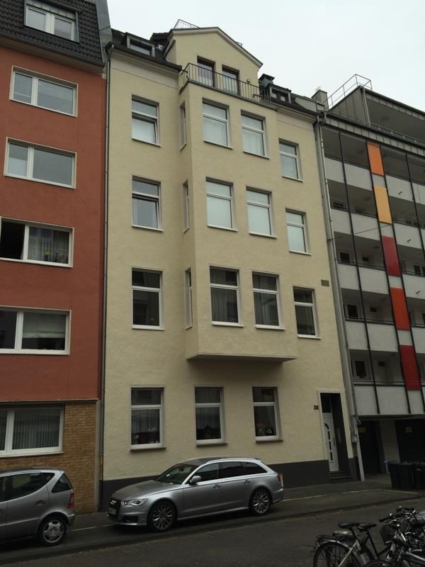 Ein Auto steht vor einem Gebäude mit vielen Fenstern