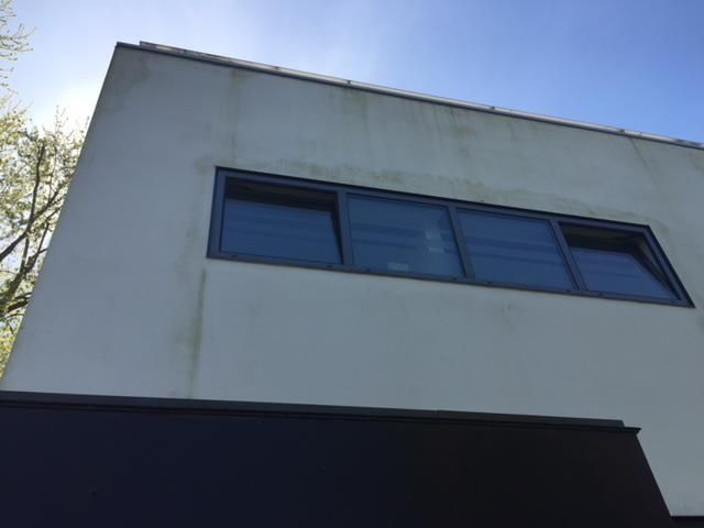 Ein Gebäude mit vielen Fenstern und einem blauen Himmel im Hintergrund