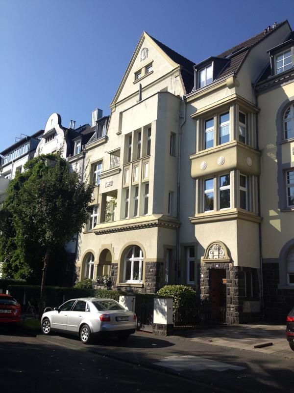 Ein weißes Auto steht vor einem großen Gebäude