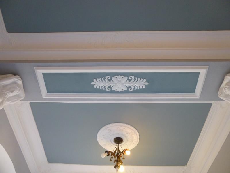 Eine blau-weiße Decke mit einem daran hängenden Kronleuchter