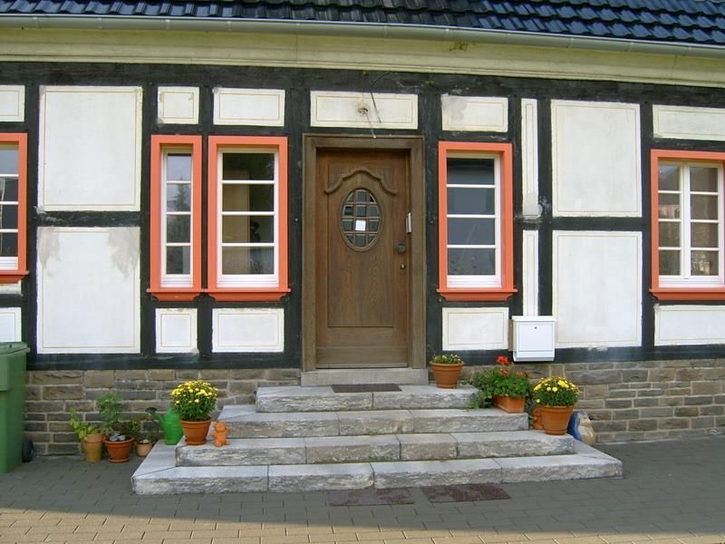 Die Vorderseite eines Hauses mit einer Holztür und Stufen