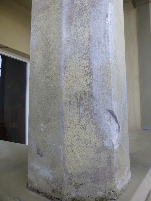 Eine Betonsäule mit einem Fenster im Hintergrund