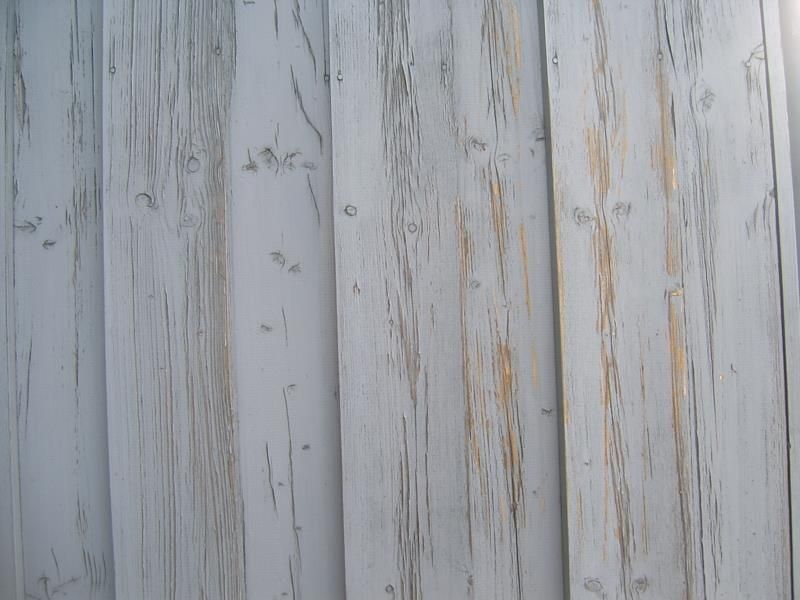 Eine Nahaufnahme von einem weißen Holzzaun mit abblätternder Farbe