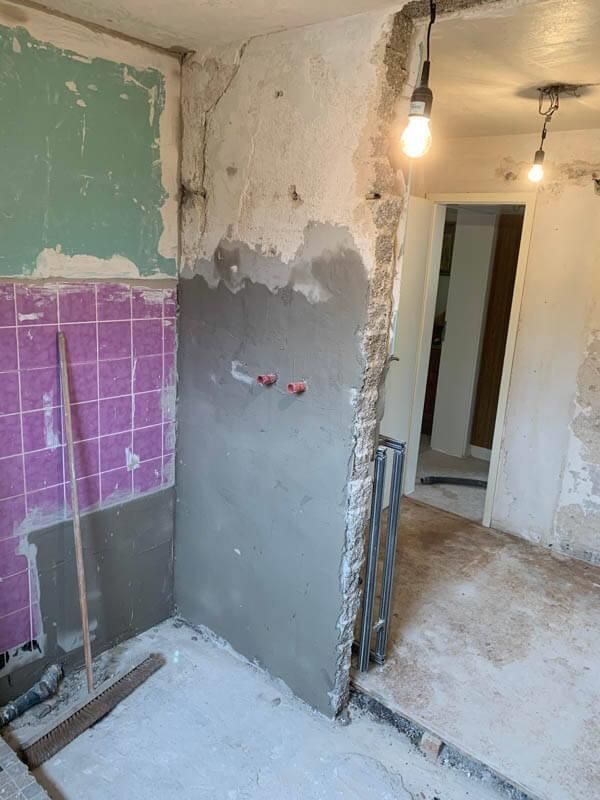 Ein Raum, der mit einer lila gefliesten Wand umgestaltet wird