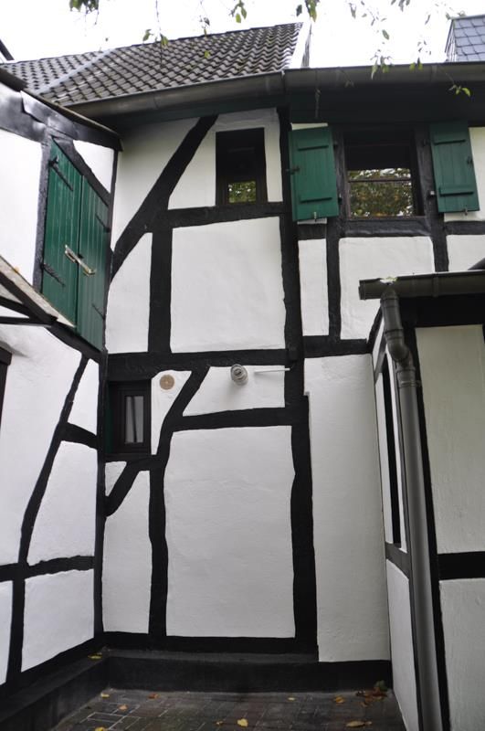 Ein schwarz-weißes Gebäude mit grünen Fensterläden