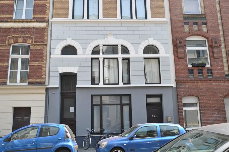 Ein blaues Auto steht vor einem Gebäude