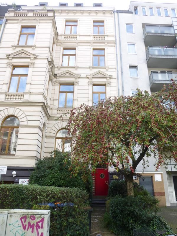 Auf einem Gebäude mit einer roten Tür steht ein Graffiti mit der Aufschrift „PMR“