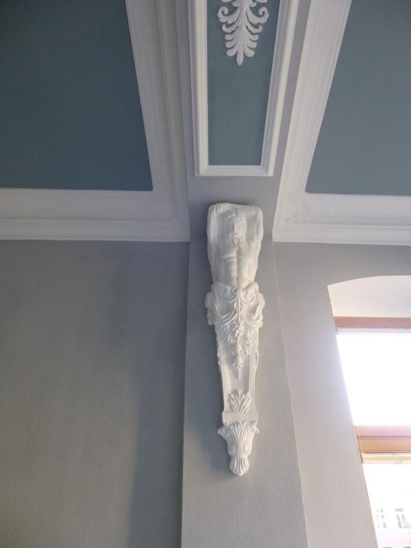 Eine weiße Statue hängt von der Decke eines Raumes