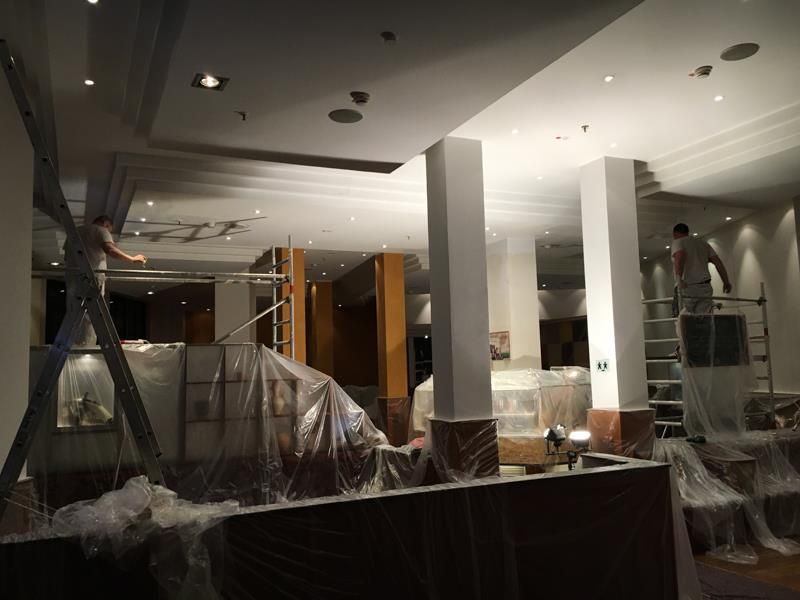 Ein Mann steht auf einer Leiter in einem leeren Raum