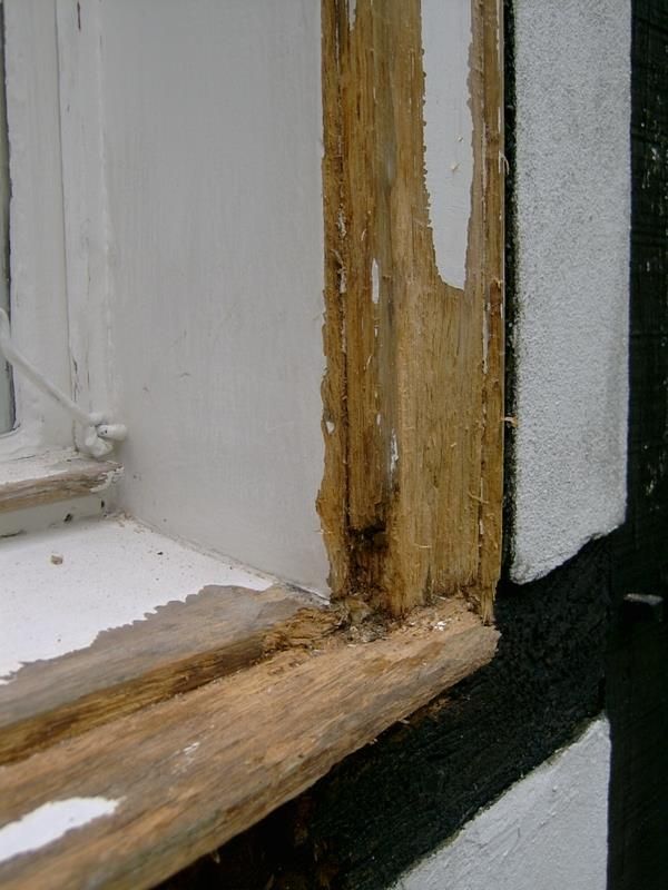 Eine Nahaufnahme von einem Fensterrahmen mit abblätternder Farbe