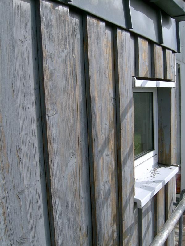 Ein Holzgebäude mit einem Fenster an der Seite