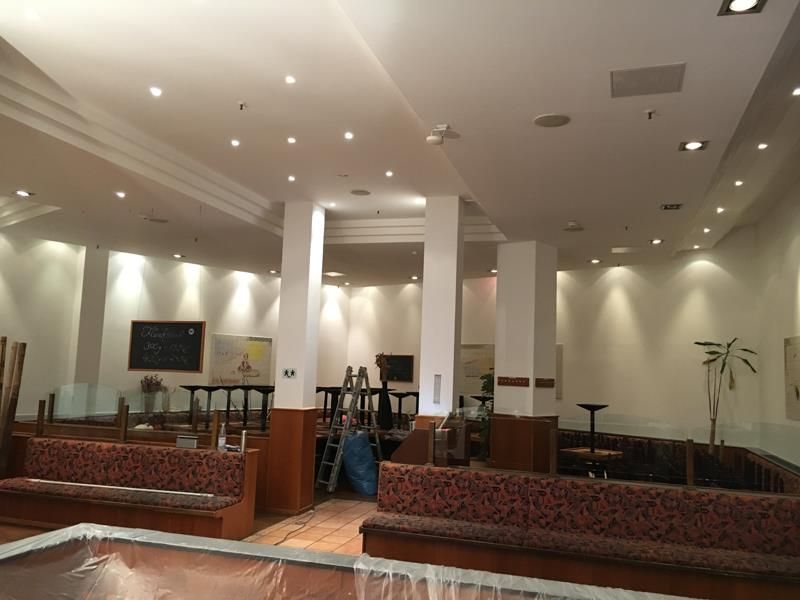 Ein großer Raum mit vielen Tischen und Bänken