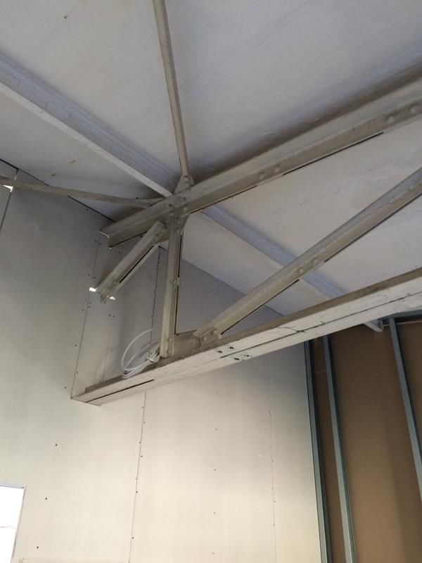 Eine Decke, von der viele Metallträger hängen.