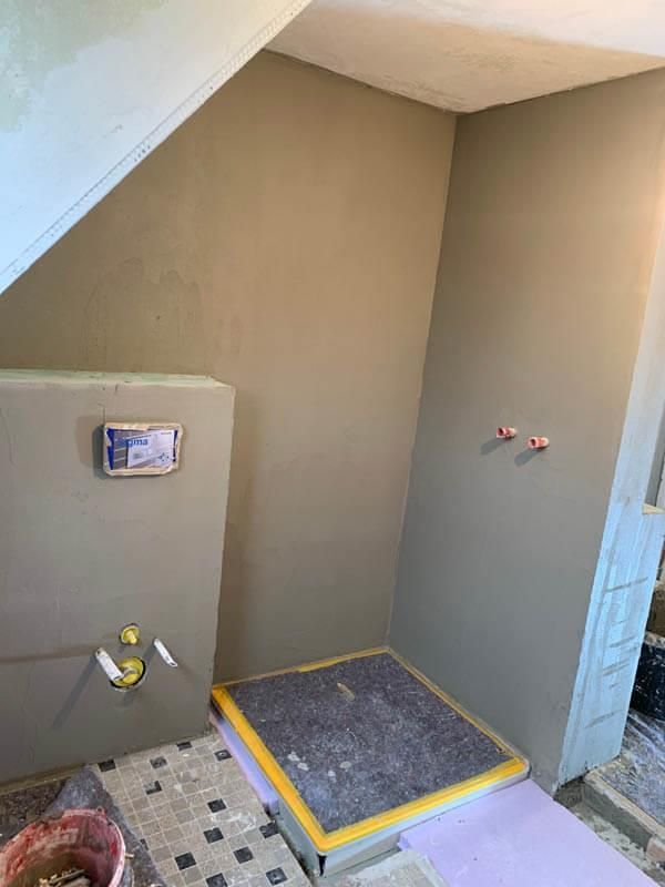 Ein im Bau befindliches Badezimmer mit Toilette und Duschkabine.