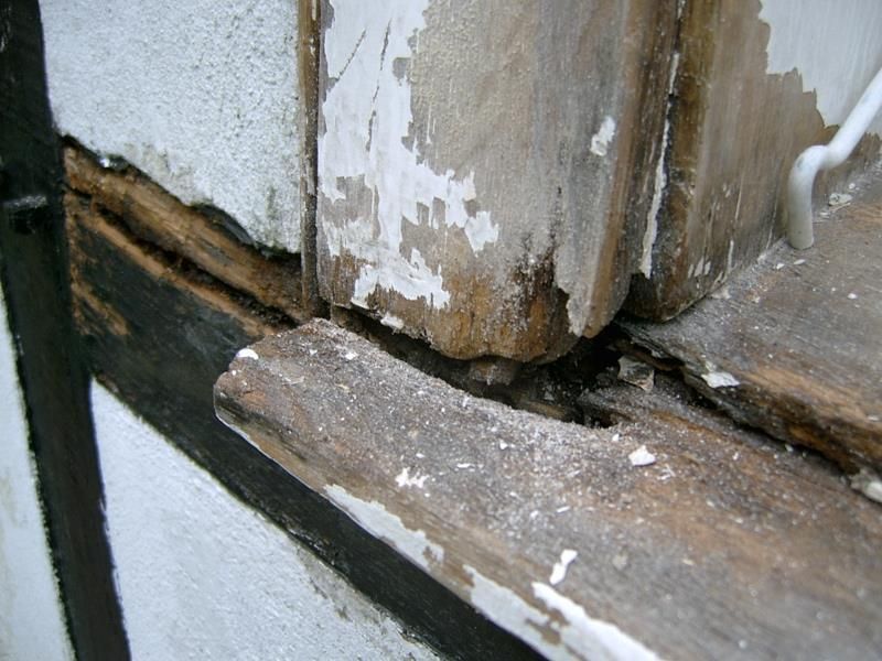 Ein Stück Holz fehlt auf einer Fensterbank