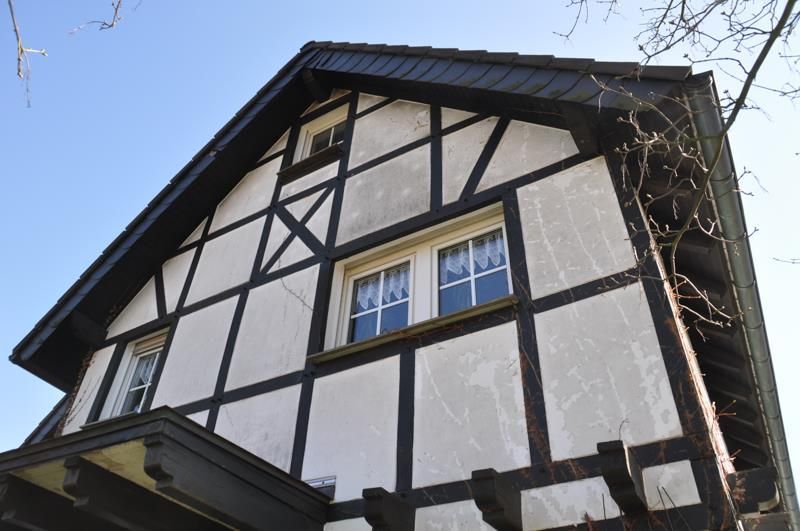 Ein schwarz-weißes Haus mit einem blauen Himmel im Hintergrund