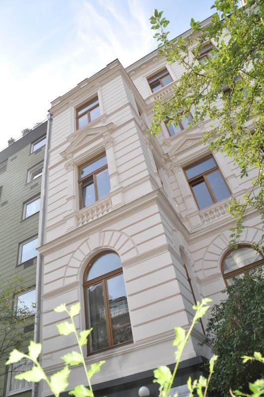 Ein Gebäude mit vielen Fenstern und einem Baum davor