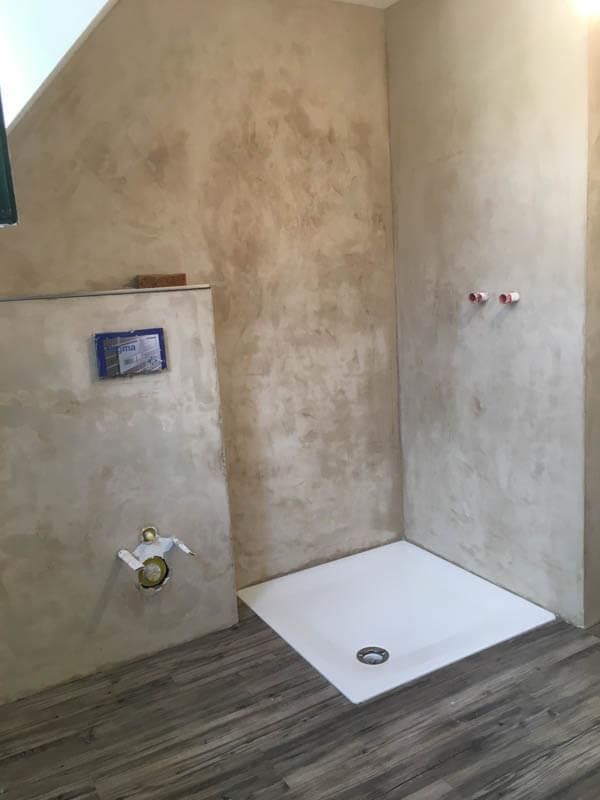 Ein Badezimmer mit ebenerdiger Dusche und Holzboden.