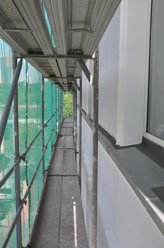 Ein langer Flur mit Gerüst an der Seite eines Gebäudes