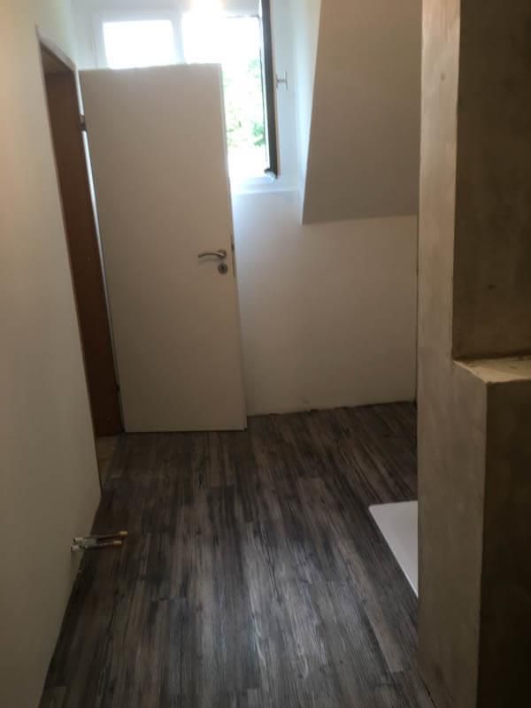 Ein Flur mit Holzboden und weißer Tür