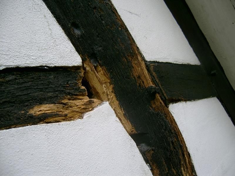 Eine schwarz-weiße Wand mit einem zerbrochenen Stück Holz