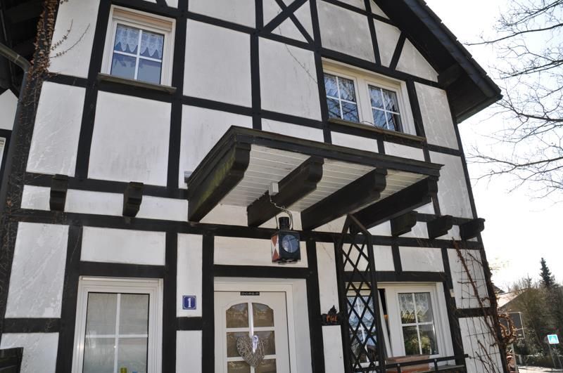 Ein schwarz-weißes Haus mit einer Uhr an der Haustür