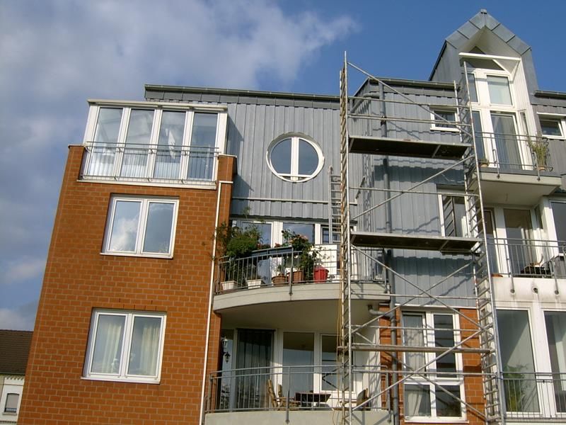 Ein Backstein-Mehrfamilienhaus mit Gerüst darum herum
