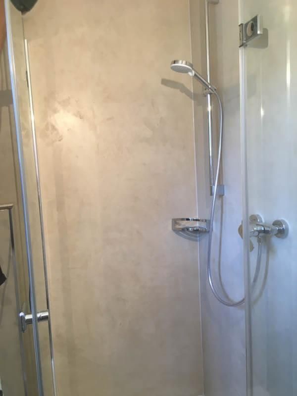 Eine Dusche mit Glastür und Duschkopf