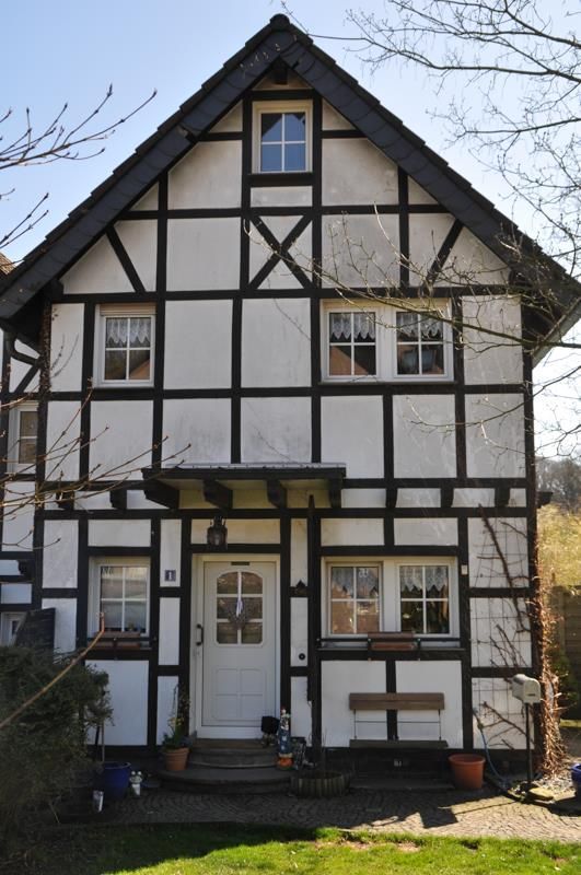 Ein schwarz-weißes Haus mit der Nummer 11 auf der Vorderseite