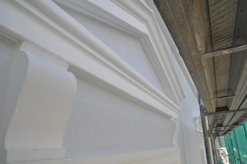 Ein weißes Gebäude mit einem Gerüst dahinter