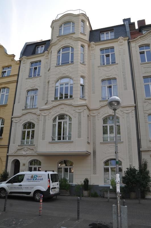 Ein weißer Lieferwagen mit der Aufschrift „ABC“ steht vor einem Gebäude