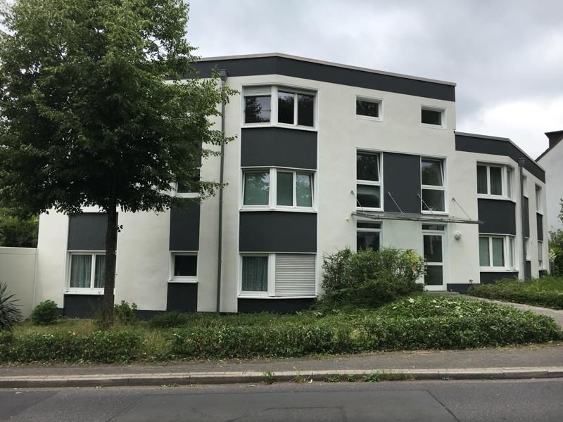 Ein weiß-schwarzes Gebäude mit einem Baum davor