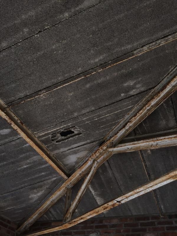 Eine Decke mit einem Loch darin und Holzbalken