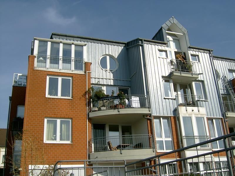 Ein Backsteingebäude mit einem Balkon im obersten Stockwerk