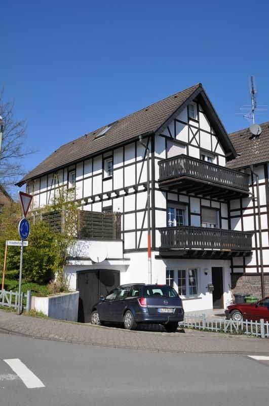 Ein Auto steht vor einem Haus mit Balkon